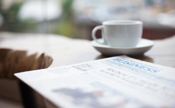 A newspaper and coffee cup