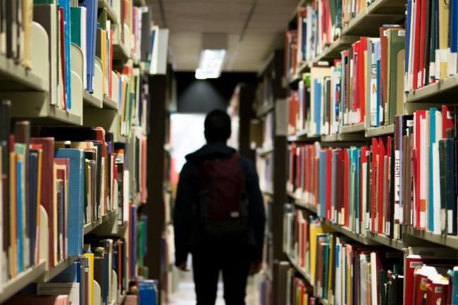 a silhouette in a library aisle