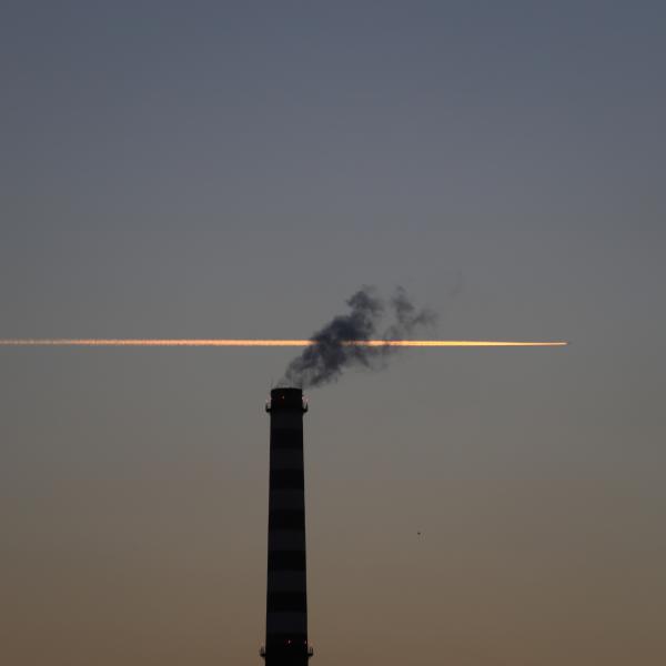 Chimney with plane trail behind
