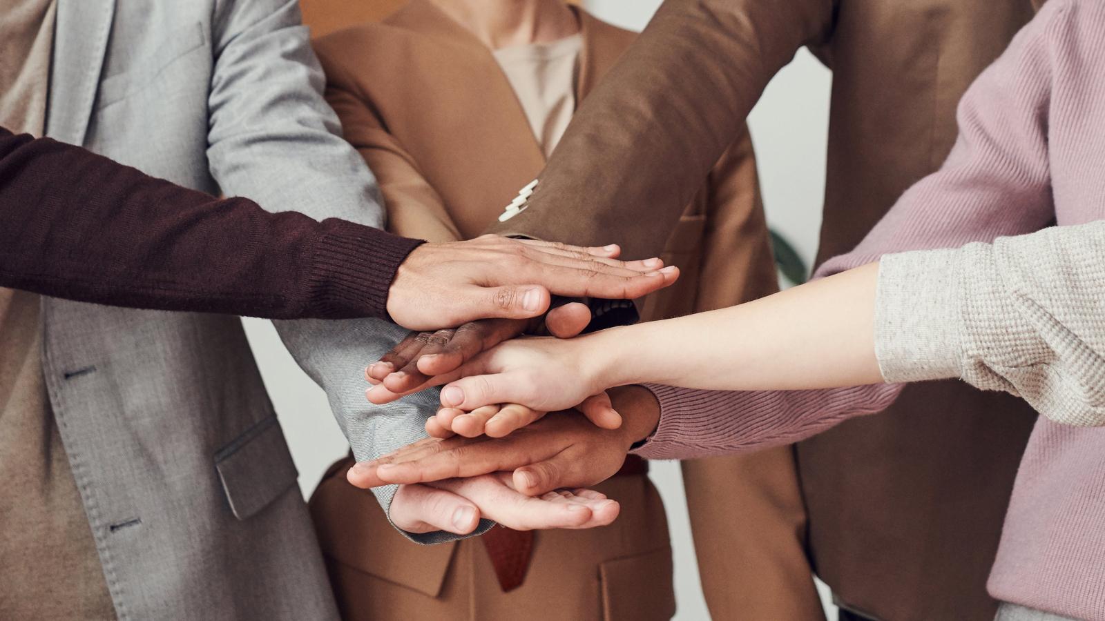 A group of people meeting hands in the centre
