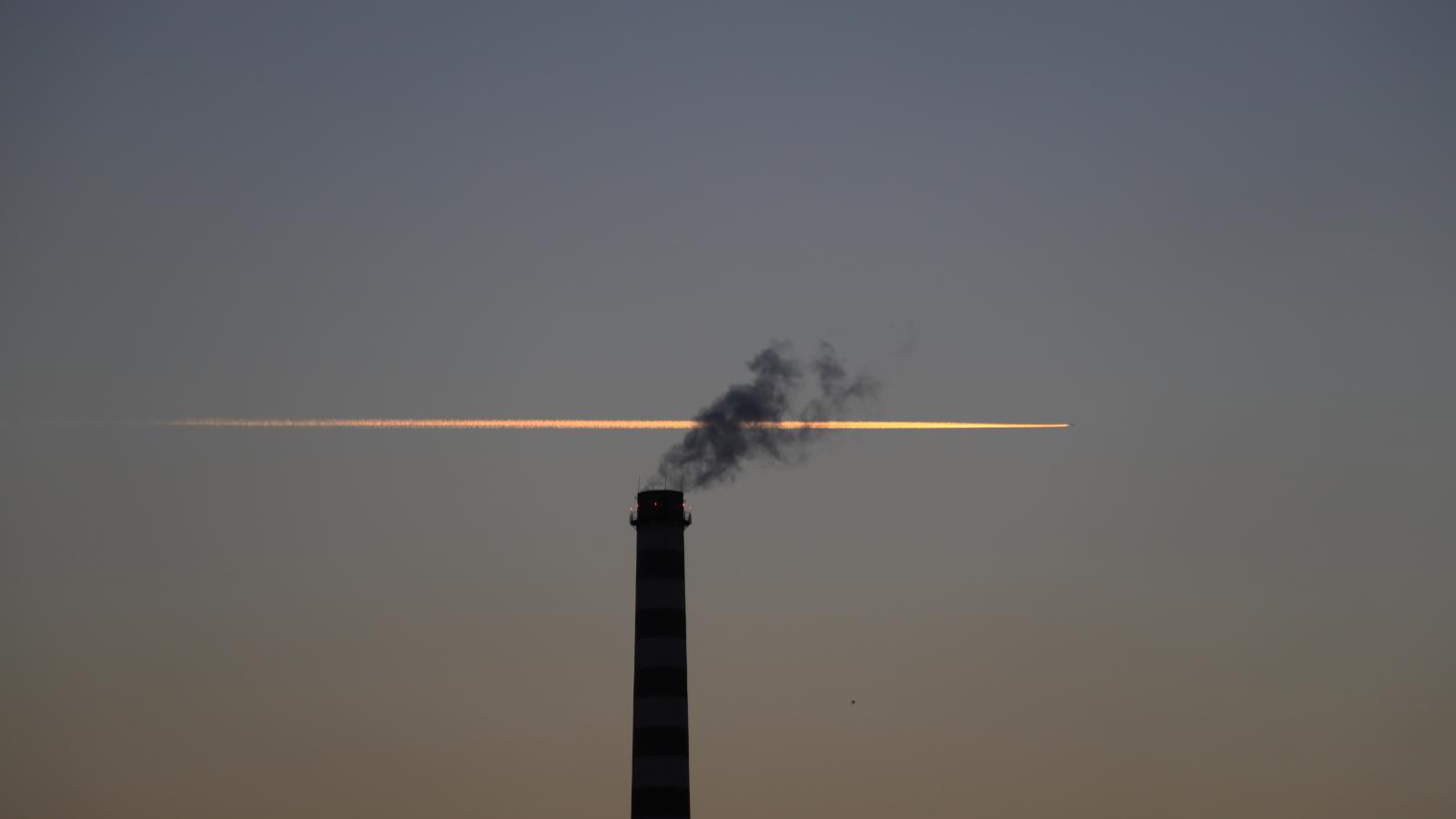 Chimney with plane trail behind